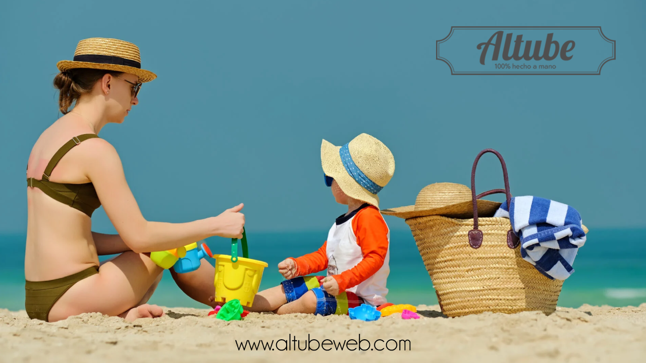 Padres disfrutando de un día de playa con su bebé, utilizando productos personalizados de Altube como mochilas y toallas multi bolsillos